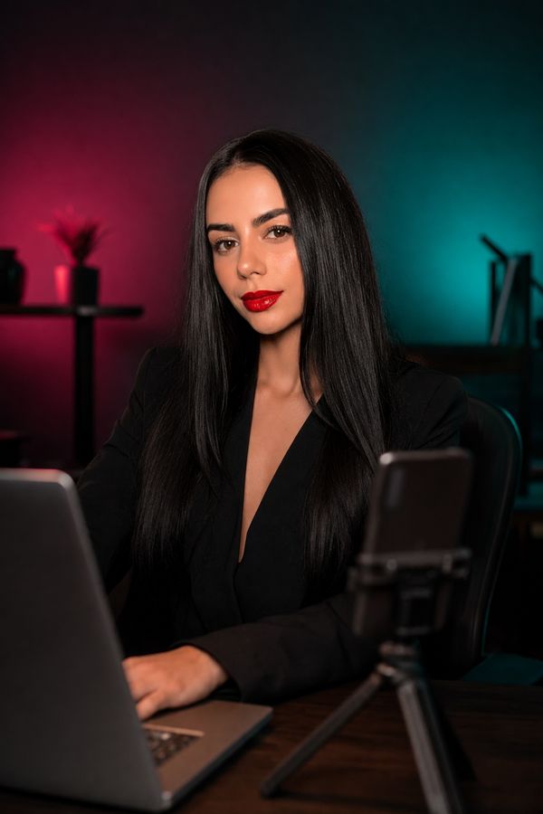 Jéssica Freire trabalhando no laptop em um escritório à noite